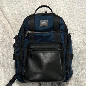 Tumi backpack in Navy with black leather accent front pocket.